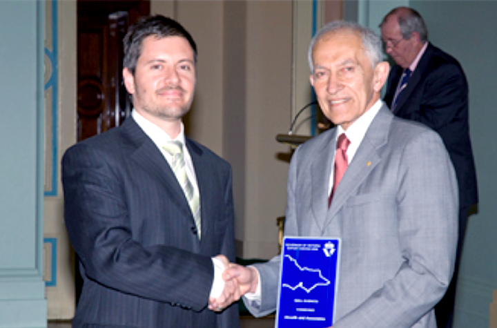 Umut Akçelik, Marketing Manager of Akcelik & Associates (left) receiving the Export Award from Professor David de Kretser, the Governor of the State of Victoria, Australia (right)